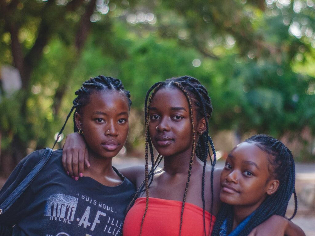 Three Black femme-presenting women in alternative fashion, celebrating alternative culture
